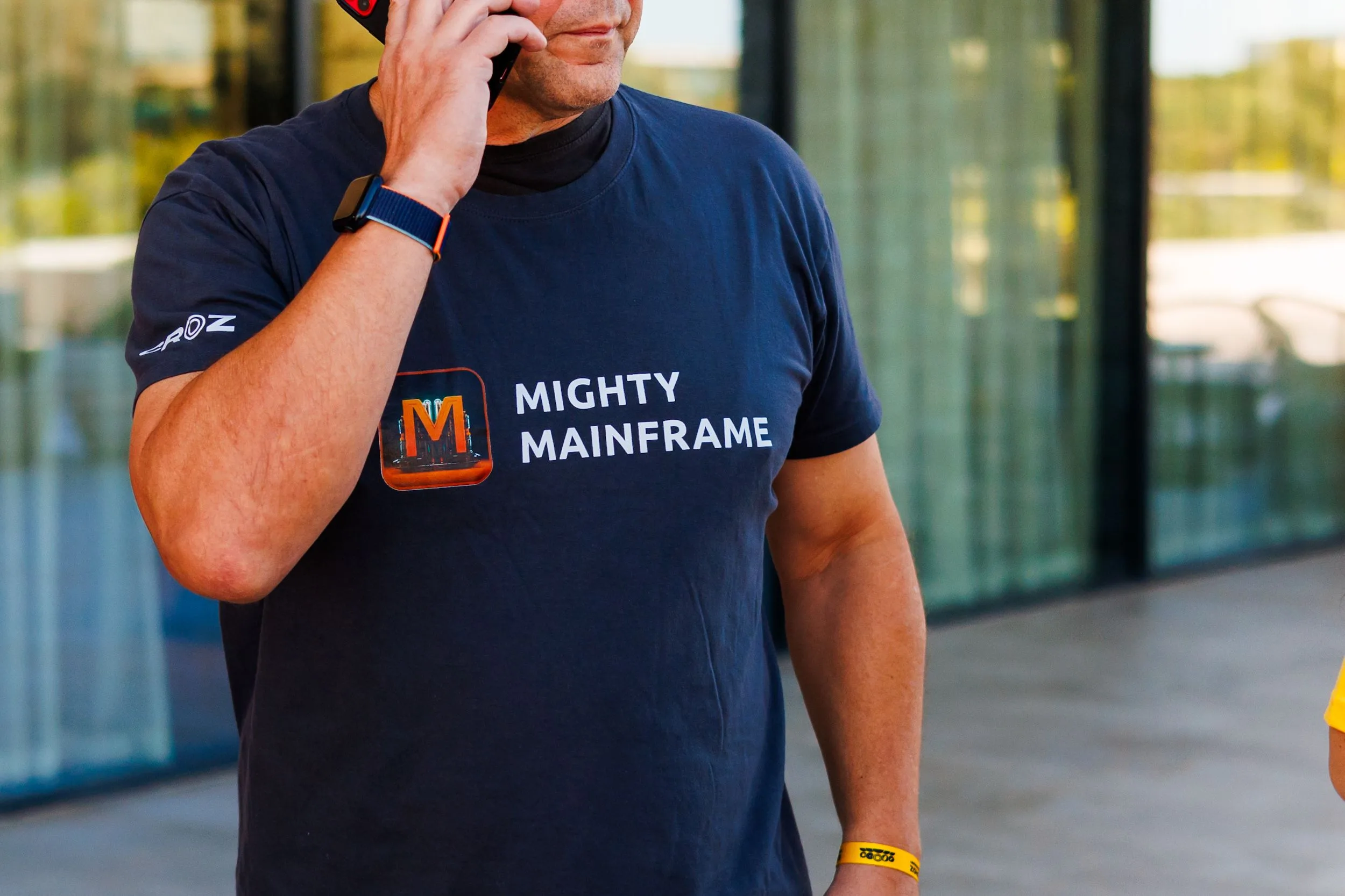 An attendee in a Mighty Mainframe T-shirt takes a phone call