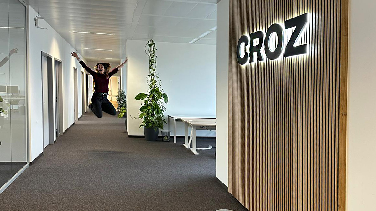 a woman happily jumping in hallway of croz office